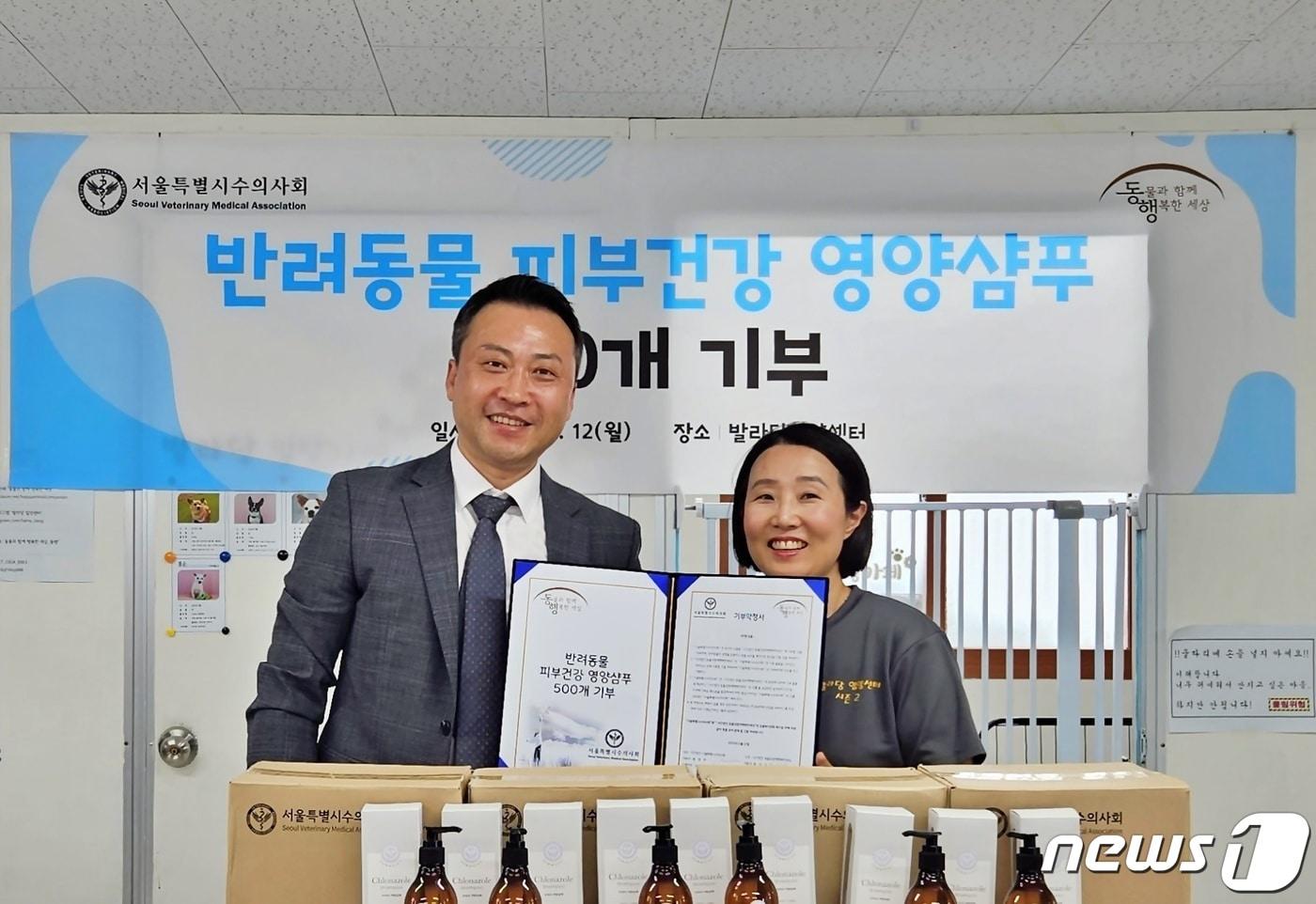 본문 이미지 - 황정연 서울시수의사회장(왼쪽)은 12일 서울 동대문구 발라당입양센터에서 최미금 동행 대표에게 반려동물 피부건강 영양샴푸를 전달했다. ⓒ 뉴스1 최서윤 기자