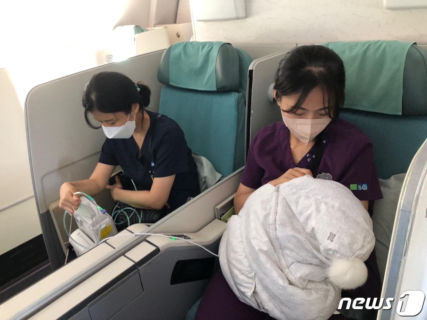 본문 이미지 - 국내 이송 비행기 안에서 미숙아 여아를 돌보는 순천향대 부천병원 의료진(순천향대 부천병원 제공)