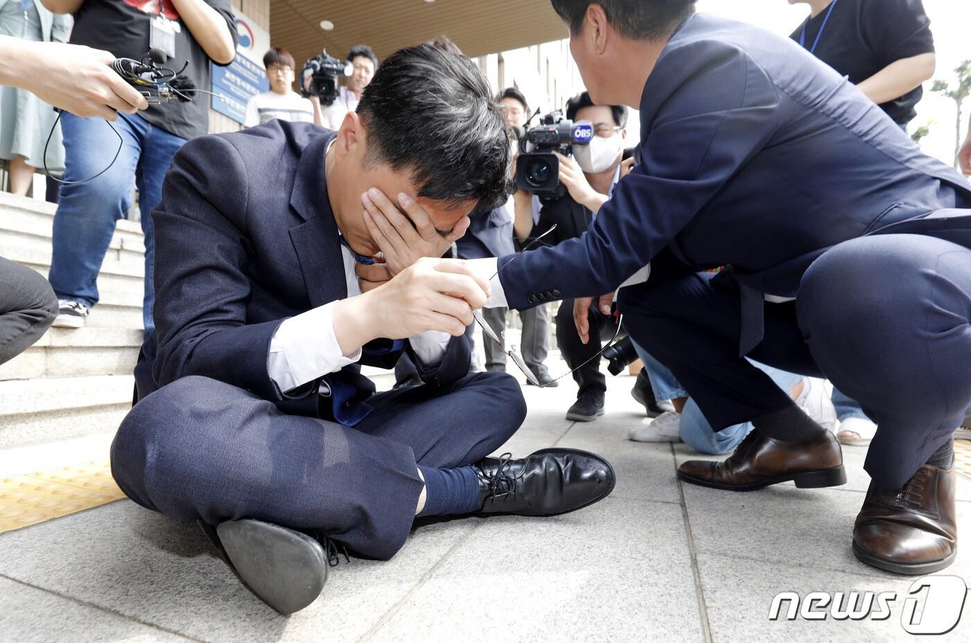 본문 이미지 - 방통위 항의 방문을 나선 장경태 더불어민주당 최고위원이 14일 경기 과천시 정부과천청사 방송통신위원회에 앞에서 성명서를 낭독하던 중 쓰러진 뒤 앉아서 휴식을 취하고 있다. 2023.6.14/뉴스1 ⓒ News1 박지혜 기자