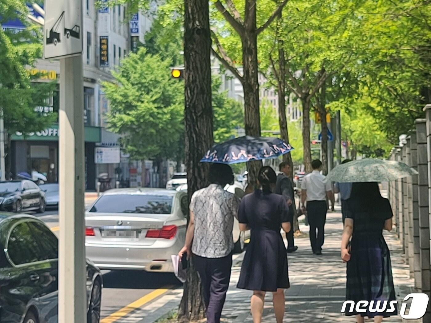 본문 이미지 - 대전 낮 최고 기온이 35도까지 오를 것으로 예보된 19일 대전 둔산동의 한 거리에서 시민들이 양산을 쓰고 이동하고 있다. /뉴스1