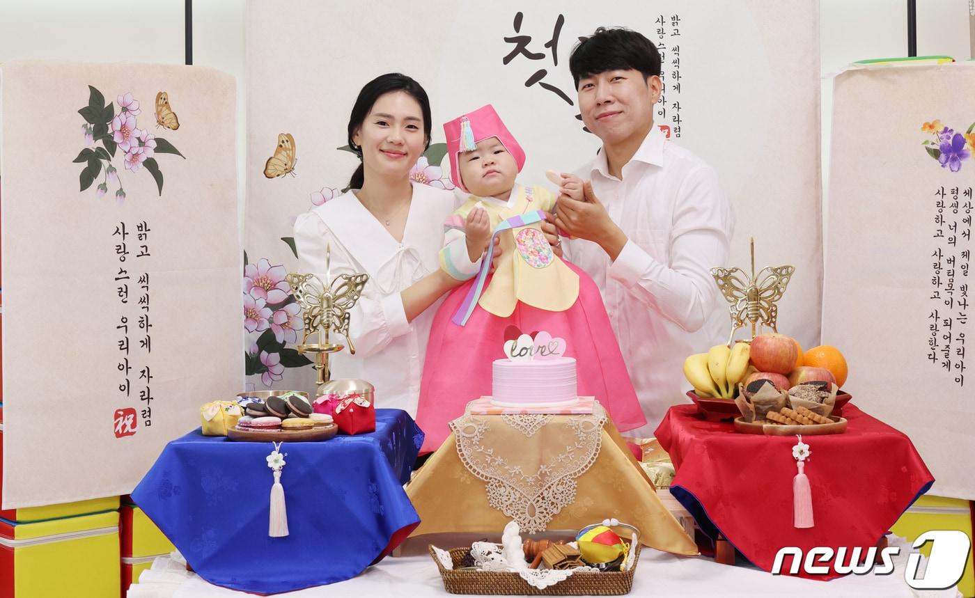 본문 이미지 - 칠곡군 아이누리장난감도서관의 돌상 무료 대여서비스를 이용한 석적읍 장동화 양 부모들이 기념사진을 찍고 있다. (칠곡군 제공)