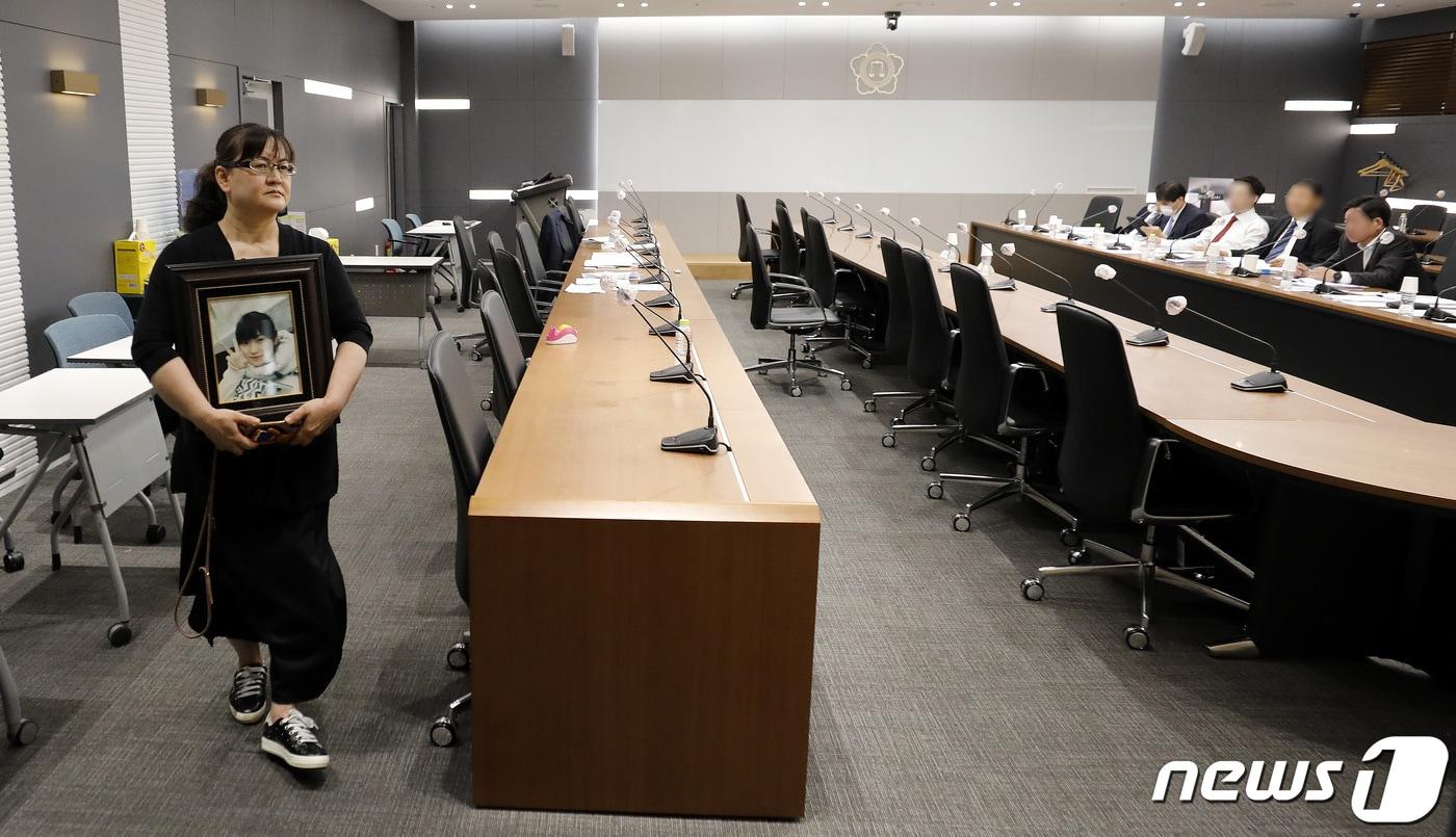 본문 이미지 - 영정 사진을 든 학교폭력 피해자 유족이 19일 서울 서초구 대한변호사협회 회관에서 열린 학교폭력 소송에 불출석해 물의를 빚은 권경애 변호사의 징계위원회에 출석해 발언을 앞두고 있다. 2023.6.19/뉴스1 ⓒ News1 박지혜 기자