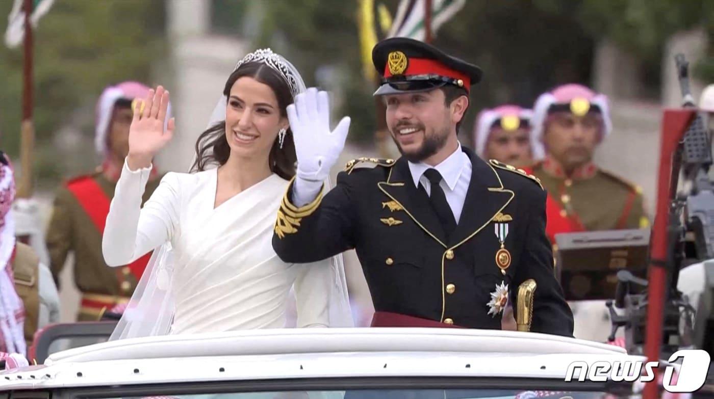 1일(현지시간) 백년가약을 맺은 알 후세인 빈 압둘라(28·왼쪽) 요르단 왕세자와 인 라즈와 알사이프(29·오른쪽)가 차량에 탑승해 군중들에게 손을 흔들고 있다. 2023.6.1 ⓒ 로이터=뉴스1 ⓒ News1 정윤미 기자