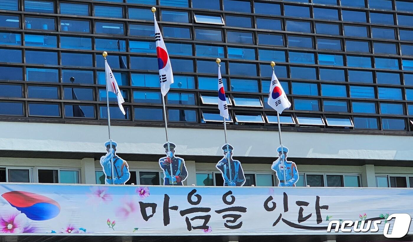 본문 이미지 - 경북 구미시는 2일 시청사 태극기 게양대에 앰비언트 기법을 이용해 육·해·공군·해병대 등 4군 의장대 모습의 실사 등신대를 결합해 마치 실제 의장대가 깃대를 들고 있는 듯한 모습의 조형물을 설치했다. 2023.6.2/뉴스1 ⓒ News1 정우용 기자