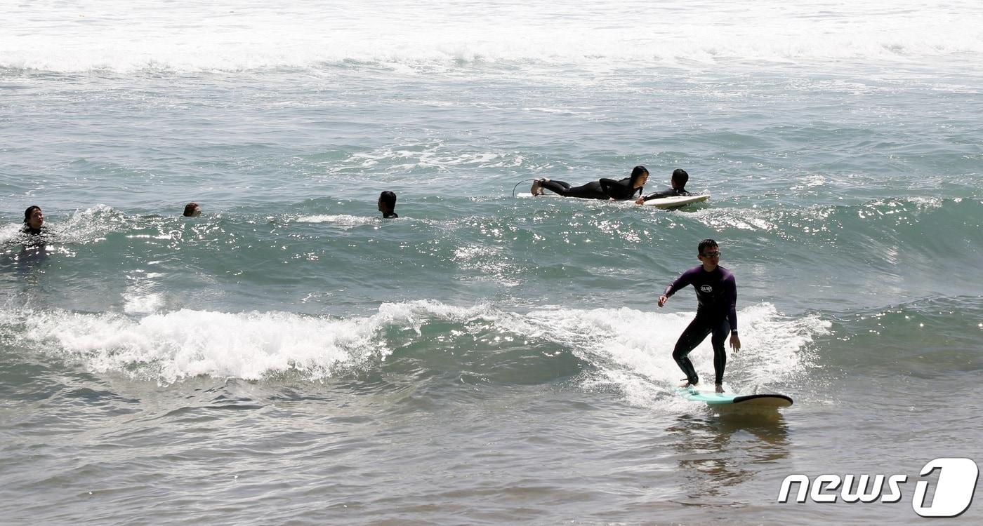 본문 이미지 - 제주 서귀포시 중문동 색달해수욕장에서 서핑을 즐기는 서퍼들.2023.6.2. ⓒ 뉴스1 고동명 기자