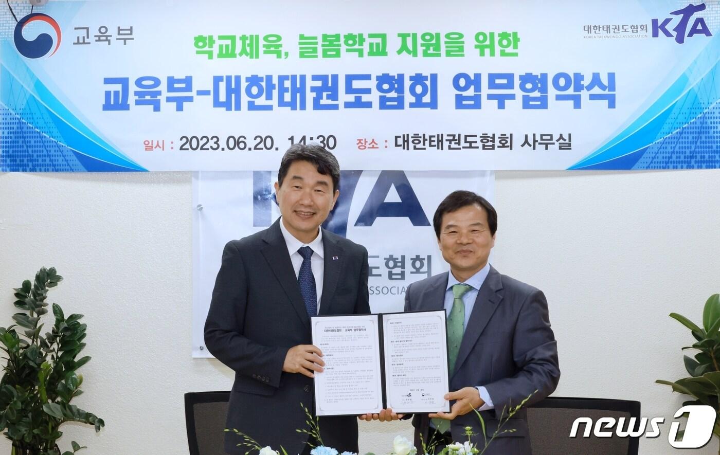 본문 이미지 - 이주호 사회부총리 겸 교육부 장관(왼쪽)과 양진방 대한택권도협회 회장이 지난 20일 서울 송파구 대한택권도협회에서 학교체육 활동 및 늘봄학교 지원을 위한 업무협약을 체결하고 있다. (교육부 제공) 