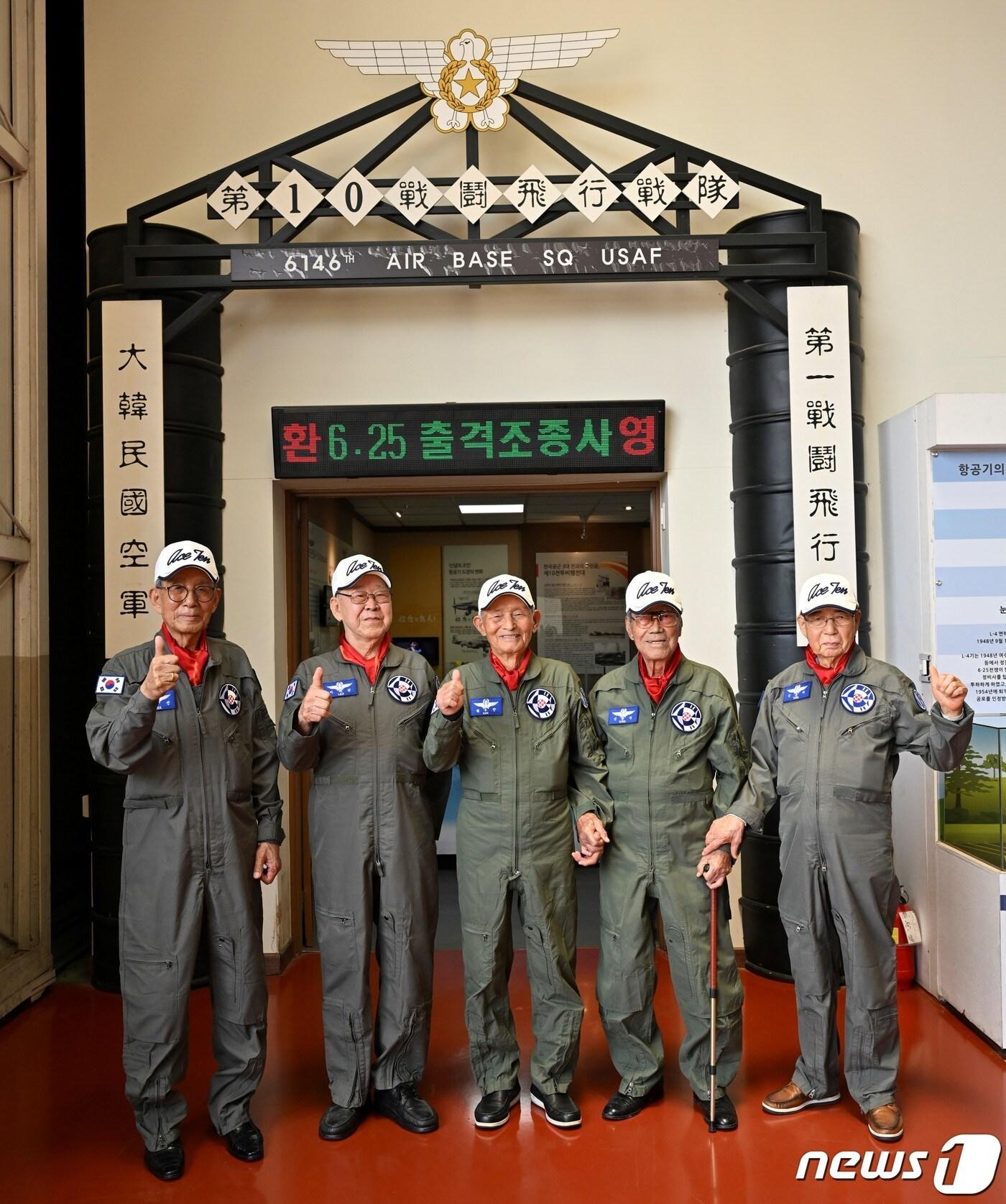 본문 이미지 - 22일 공군 제10전투비행단에서 열린 ‘6·25 출격조종사 초청행사’에 참석한 전쟁 당시 출격 조종사들이 복원된 옛 ‘제10전투비행전대’ 영문 앞에서 기념촬영을 하고 있다. 왼쪽부터 이학선 예비역 중령, 이배선 예비역 대령, 김두만 예비역 대장, 신관식 예비역 대령, 신준기 예비역 대령. (공군 제공) 2023.6.22/뉴스1