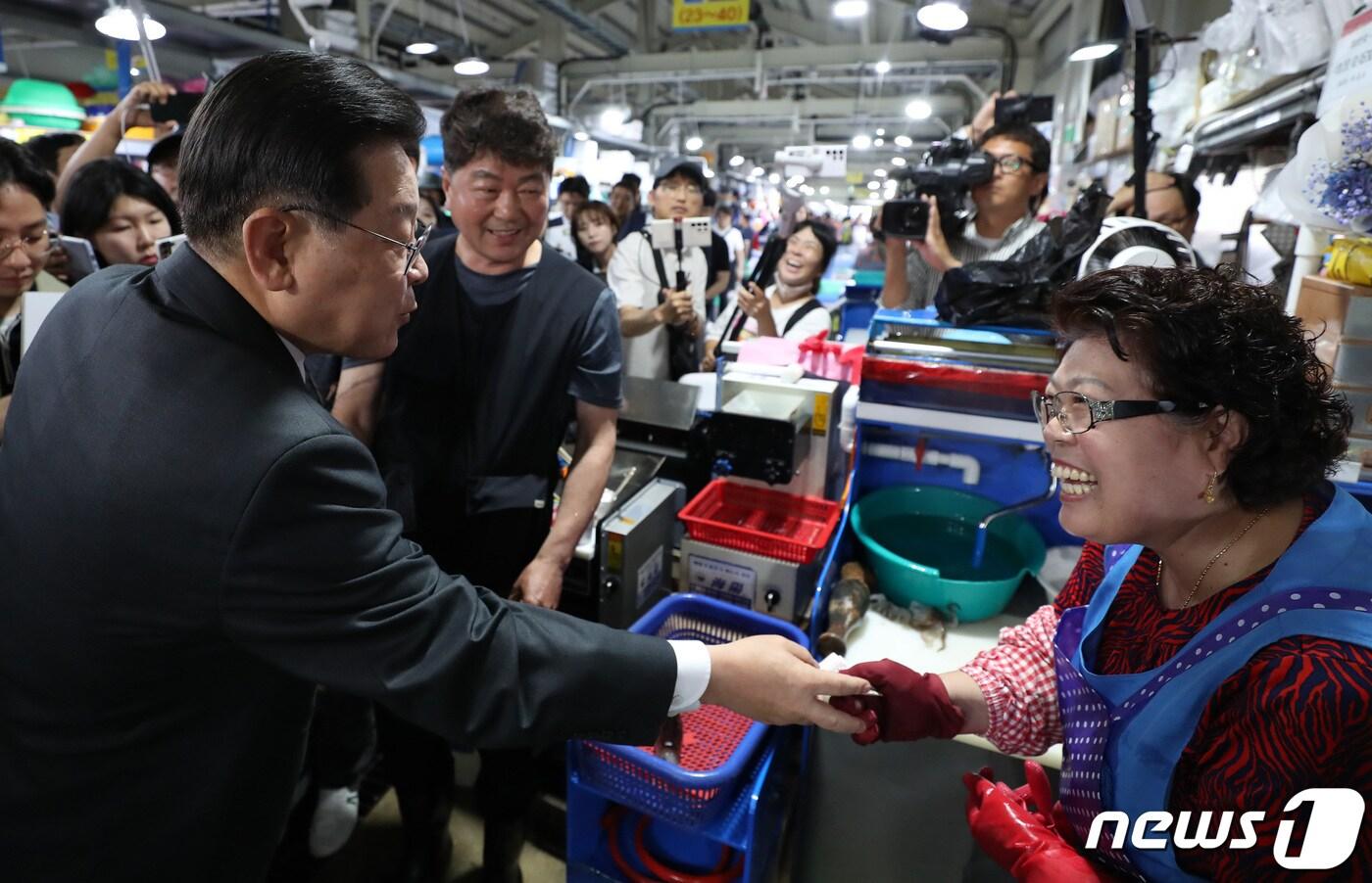 본문 이미지 - 이재명 더불어민주당 대표가 22일 오후 강원 강릉시 주문진 좌판풍물시장을 찾아 오징어회를 시식한 후 손질비용을 계산하고 있다. (공동취재) 2023.6.22/뉴스1 ⓒ News1 황기선 기자