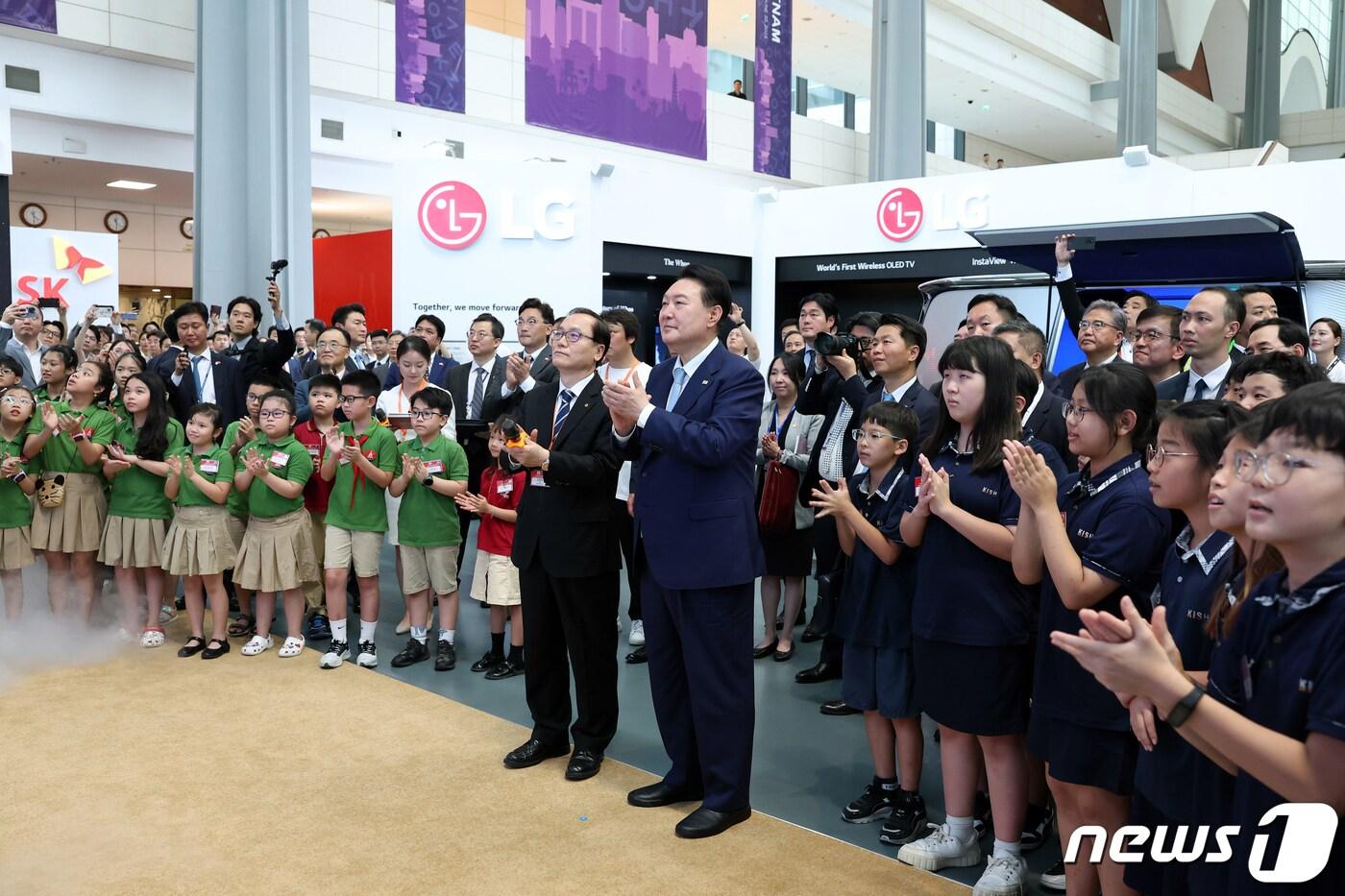 본문 이미지 - 윤석열 대통령이 22일(현지시간) 하노이 국가컨벤션센터(NCC)에서 열린 한·베트남 파트너십 박람회를 방문해 한화 전시장을 찾아 누리호 모형과 발사 장면을 한국국제학교와 현지 학교 학생들과 지켜보며 손뼉치고 있다. (대통령실 홈페이지) 2023.6.22/뉴스1 ⓒ News1 안은나 기자