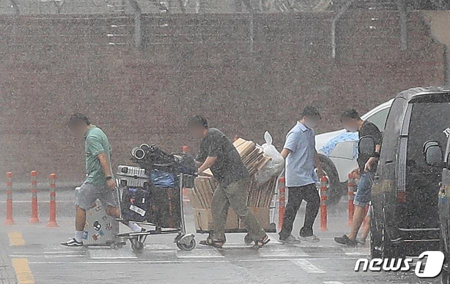 본문 이미지 - 제주를 비롯한 남부지방에 장마가 시작된 25일 제주국제공항에서 관광객들이 장맛비를 피하며 급하게 발걸음을 옮기고 있다.2023.6.25/뉴스1 ⓒ News1 강승남 기자