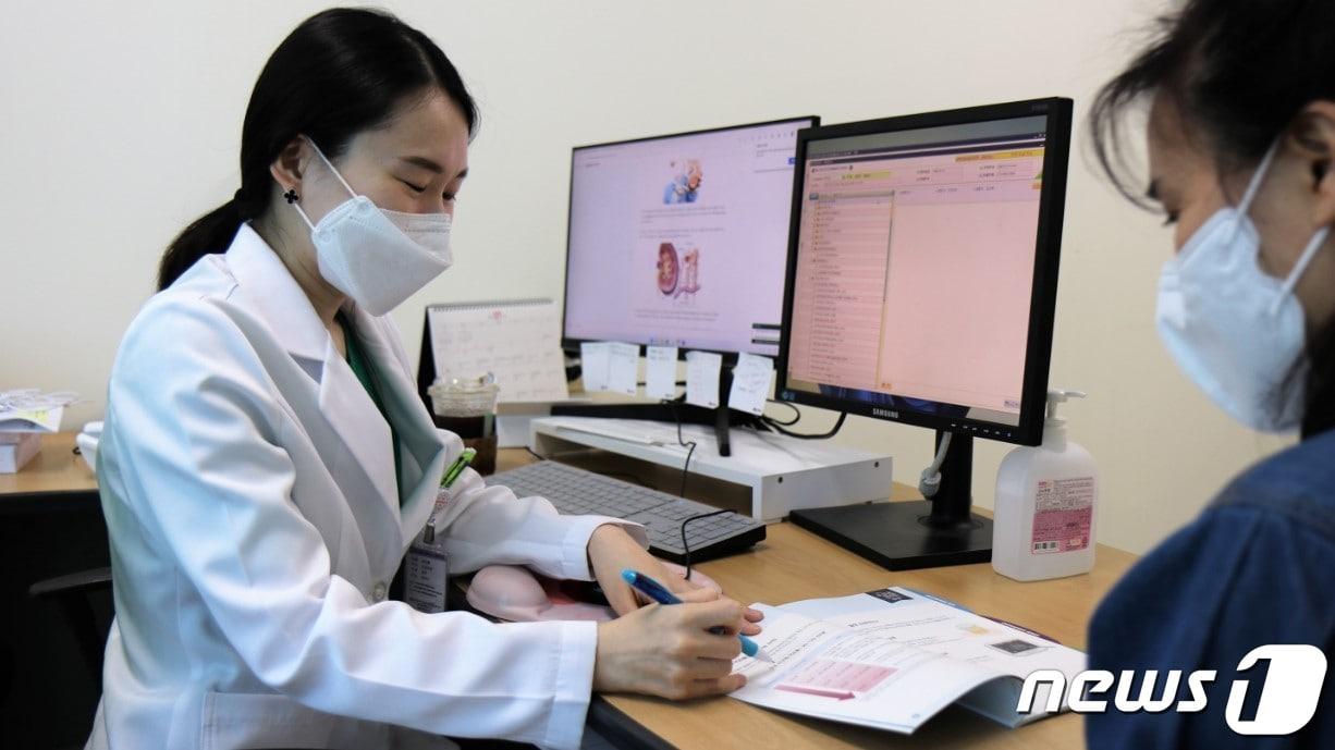 본문 이미지 - 김진혜 부산성모병원 신장내과 과장이 환자에게 단백뇨에 대해 설명하고 있다(부산성모병원 제공).