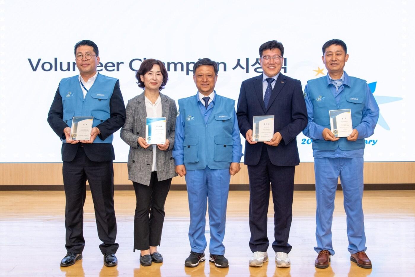 본문 이미지 - 6월 14일 열린 포스코봉사단 20주년 기념행사에서 포스코 포항 행복나눔벽화봉사단, 포항재가노인통합지원센터, 광양 중마노인복지관, 포스코 광양 클린오션봉사단이 볼런티어 챔피언으로 선정됐다. (왼쪽부터)최재호 포항 행복나눔벽화봉사단 사무국장, 안은영 포항재가노인통합지원센터 센터장, 김학동 포스코 부회장, 정병관 광양 중마노인복지관 관장, 정중영 광양 클린오션봉사단 단장(포스코그룹 제공).