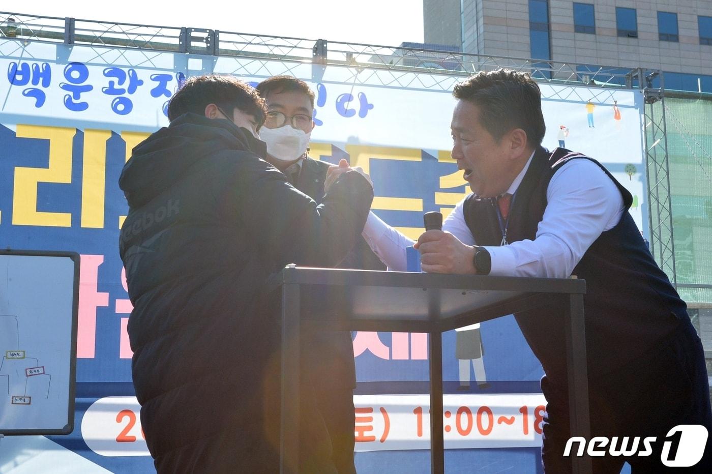 본문 이미지 - 김병내 광주 남구청장이 백운광장 스트리트 푸드존 일원에서 진행된 ‘한마음 축제 팔씨름대회'에 출전해 준비 자세를 취하고 있다.(광주 남구청 제공) 2023.7.1/뉴스1