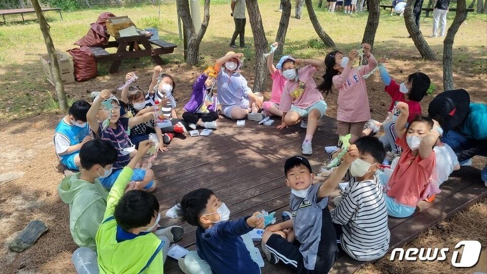 본문 이미지 - 진도 조도초등학교(교장 심우창 ) 전교생 39명과 교직원들이 반려해변인 신전해수욕장에서 폐어구를 비롯한 생활 쓰레기를 치운 뒤 폐플라스틱을 활용해 만든 바다생물 키링을 선보이고 있다. 반려 해변 제도는 학교·기업·단체가특정해변을 맡아 반려동물처럼 가꾸고 돌보는 환경정화 활동의 하나로 지난 2021년 해양수산부 사업으로 시작됐다.(전남교육청 제공)/뉴스1   
