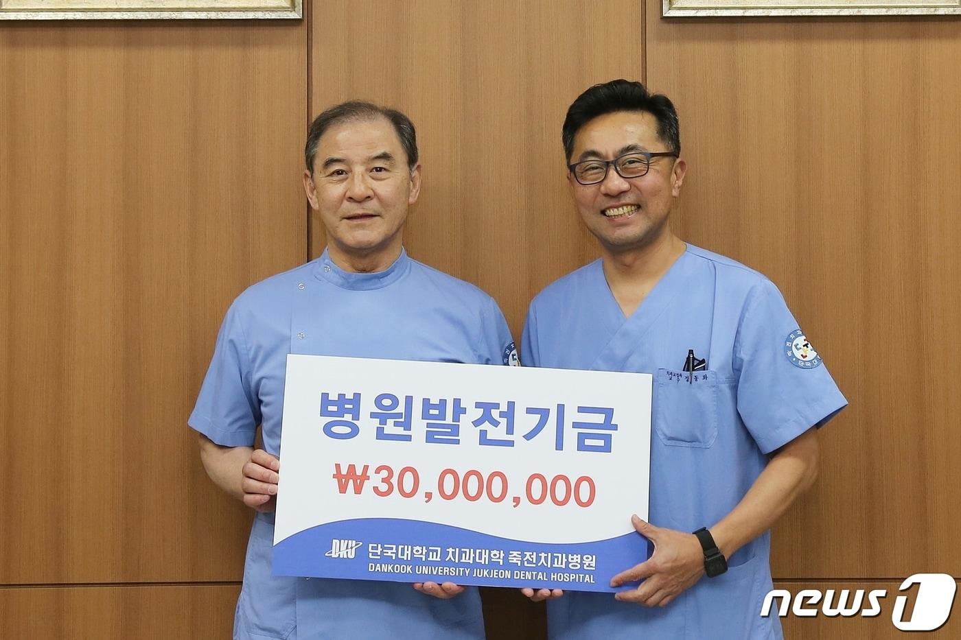 홍찬의 석좌교수(왼쪽)가 정동화 단국대 죽전치과병원장에게 발전기금을 전달하고 있다.(단국대 제공)