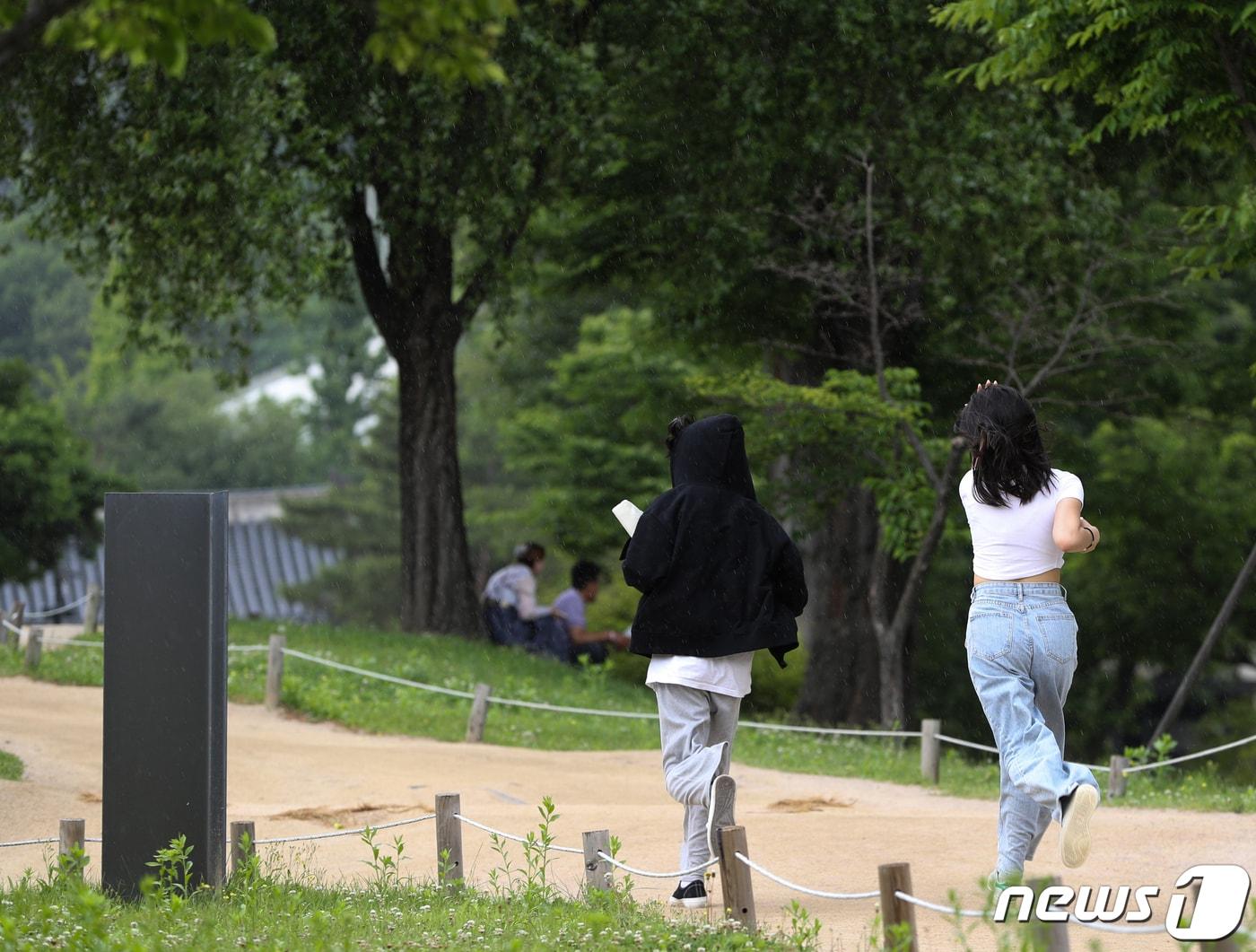 본문 이미지 - 6일 오후 서울 경복궁에서 관람객들이 갑자기 내리는 소나기를 피하고 있다. 2023.6.6/뉴스1 ⓒ News1 신웅수 기자