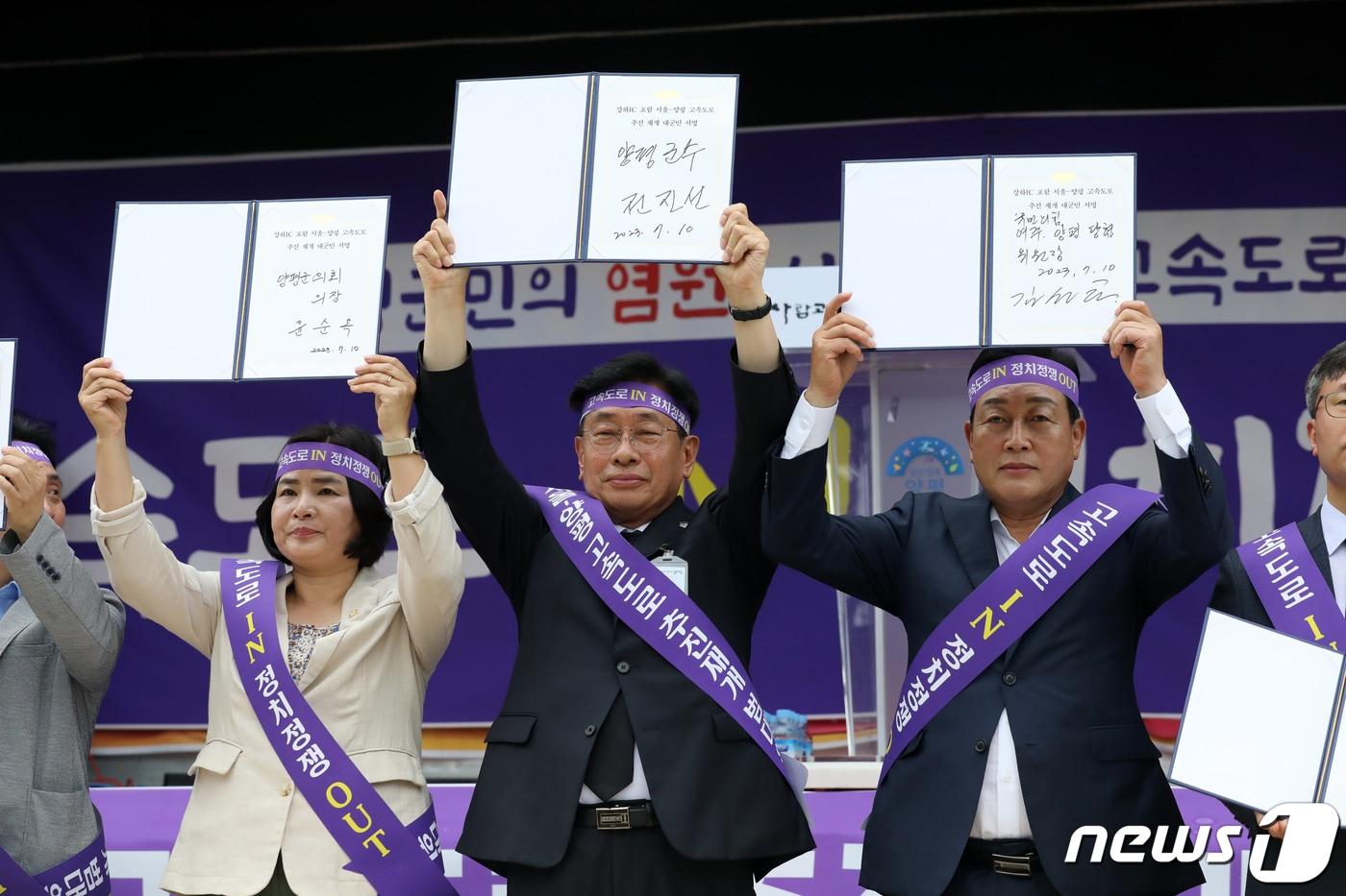 본문 이미지 - 전진선 양평군수가 경기도 양평군청 앞에서 열린 '서울-양평 고속도로 재개 범군민 대책위원회 출정식'에 참석해 고속도로 사업 재개를 촉구하는 대군민 서명을 한 뒤 들어보이고 있다.2023.7.10 ⓒ 뉴스1 이승배 기자