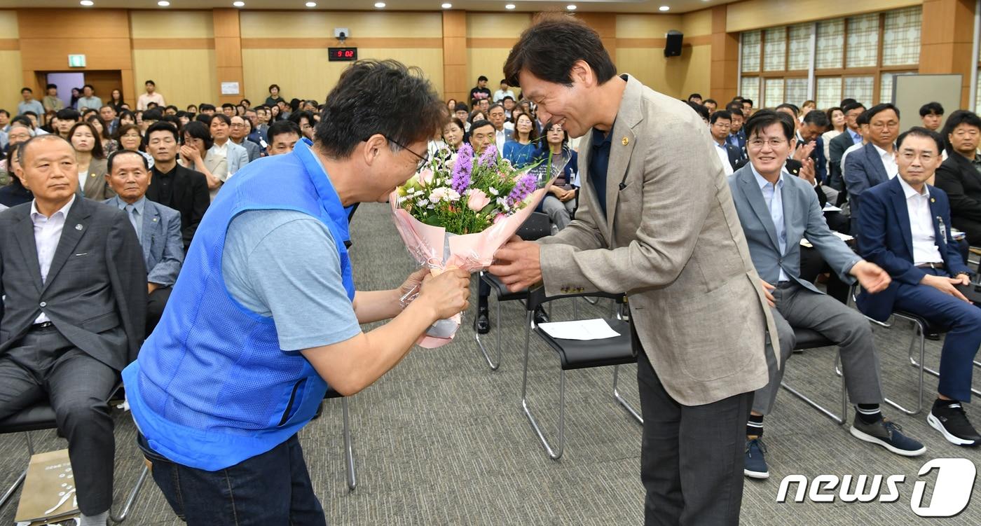 본문 이미지 - 조현일 경산시장이 10일 정례회에서 이상현 경산시공무원노조위원장으로부터 취임 1주년 축하 꽃다발을 받고 있다. (경산시 제공) 2023.7.10/뉴스1