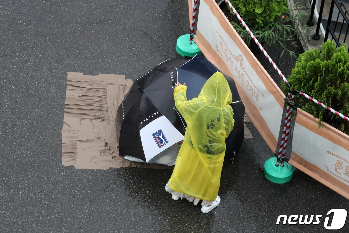 본문 이미지 - 서울 중구 서울역 앞에서 한 노숙자가 자리를 보호하는 우산을 옮기고 있다. ⓒ News1 이승배 기자