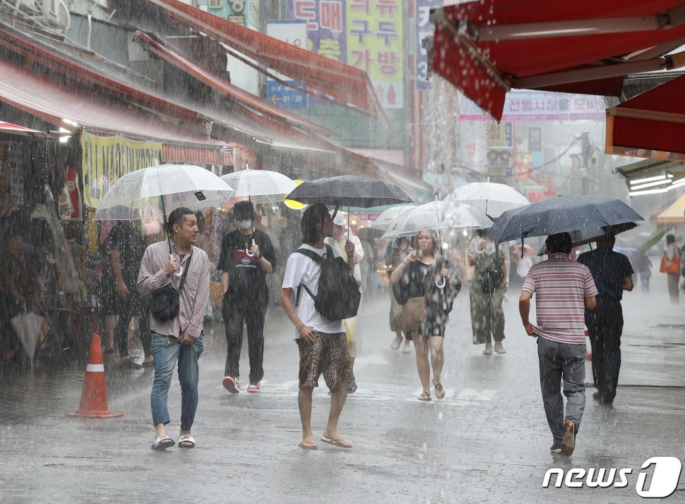 본문 이미지 - 수도권 지역에 호우특보가 내려진 11일 서울 남대문시장에 시민들이 우산을 쓰고 발걸음을 옮기고 있다. 2023.7.11/뉴스1 ⓒ News1 신웅수 기자