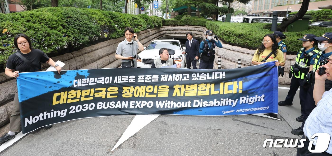 본문 이미지 - 전국장애인차별철폐연대(전장연)이 12일 서울 중구 롯데호텔 지하주차장 출구에서 한덕수 국무총리와의 면담을 요청하며 시위를 벌이고 있다. 한 총리는 이날 같은 장소에서 열린 정보보호의 날 기념식에 참석했다. 2023.7.12/뉴스1 ⓒ News1 허경 기자