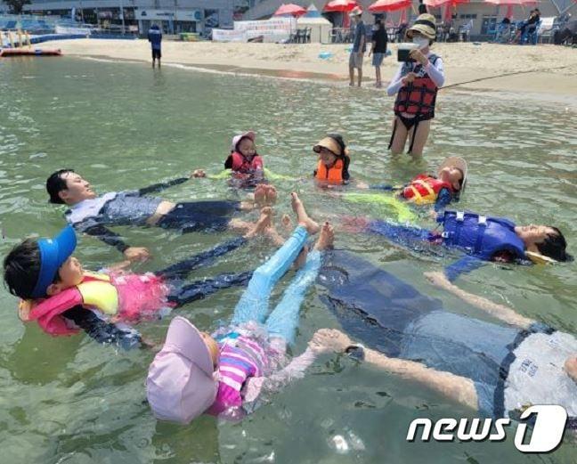 본문 이미지 - 부산해경이 해수욕장에서 일반 시민을 대상으로 생존수영을 교육하고 있다.(부산해경 제공)