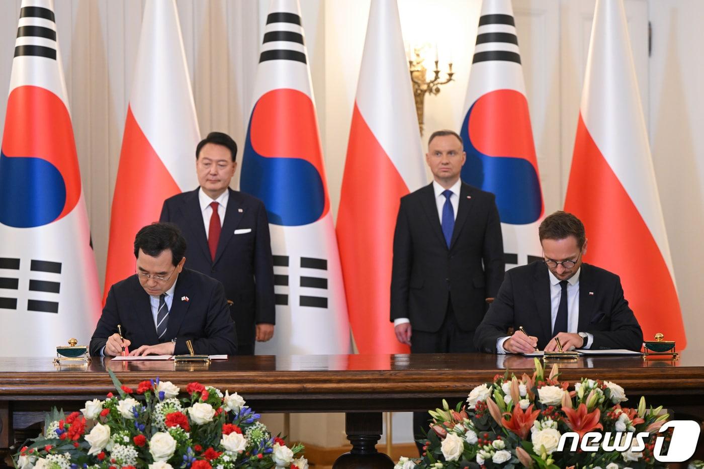 본문 이미지 - 이창양 산업통상자원부 장관과 발데마르 부다 폴란드 경제개발기술부 장관이 13일(현지시간) 폴란드 바르샤바 대통령궁에서 윤석열 대통령과 안제이 두다 폴란드 대통령이 지켜보는 가운데 한·폴란드 무역투자촉진프레임워크(TIPF) 협정에 서명하고 있다. (대통령실 홈페이지) 2023.7.14/뉴스1 ⓒ News1 오대일 기자