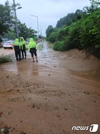 본문 이미지 - 밤 사이 내린 비로 14일 오전 광주 북구 신용동의 한 도로에 토사가 유출돼 소방당국이 배수 작업을 하고 있다. (광주 북구 제공) 2023.7.14/뉴스1 