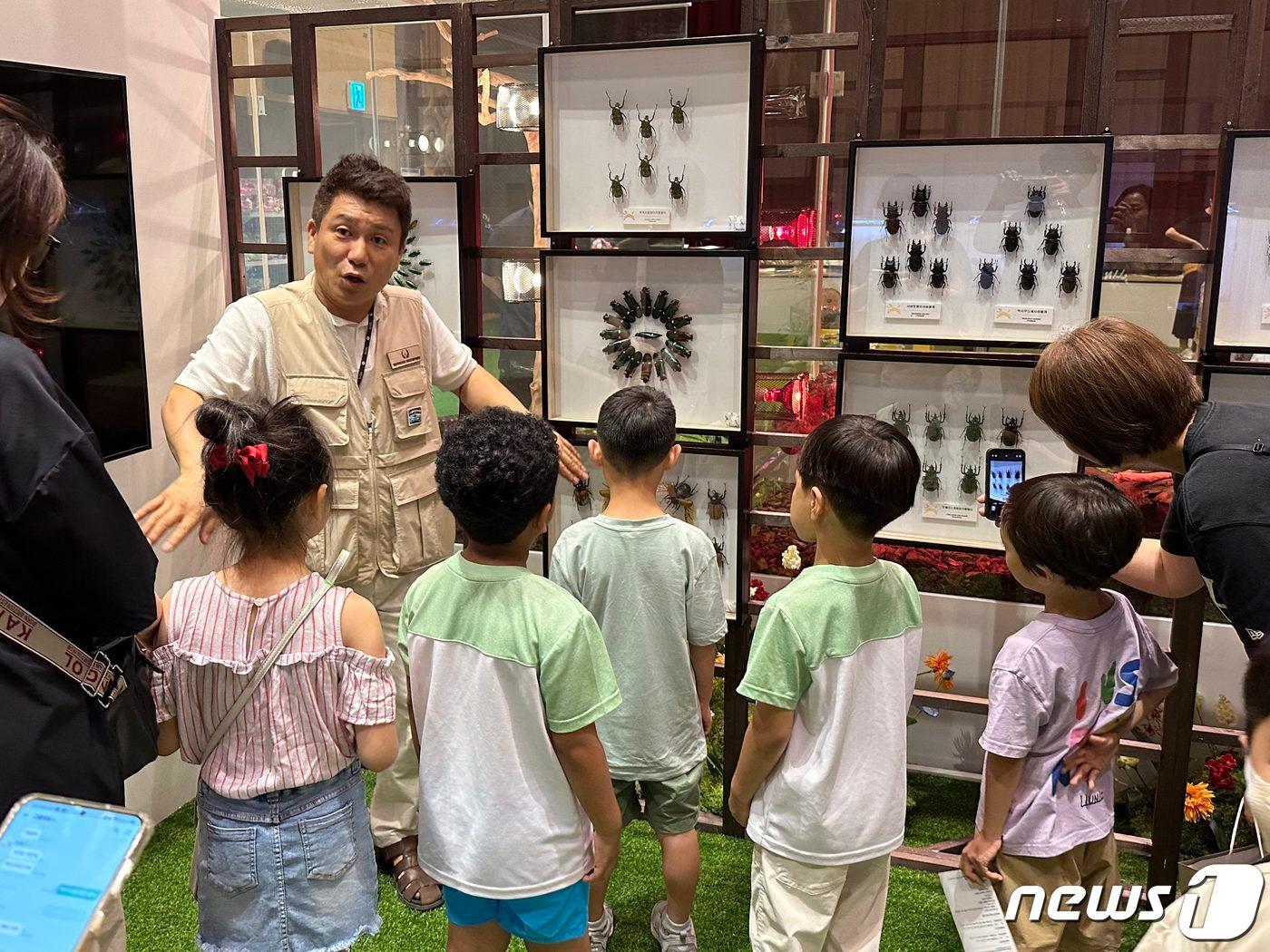 본문 이미지 - 경기 고양시 일산동구 장항동 롯데백화점 일산점에서 '옐로우지브라 곤충박물관'을 체험 중인 아이들과 해설사(롯데쇼핑 제공)