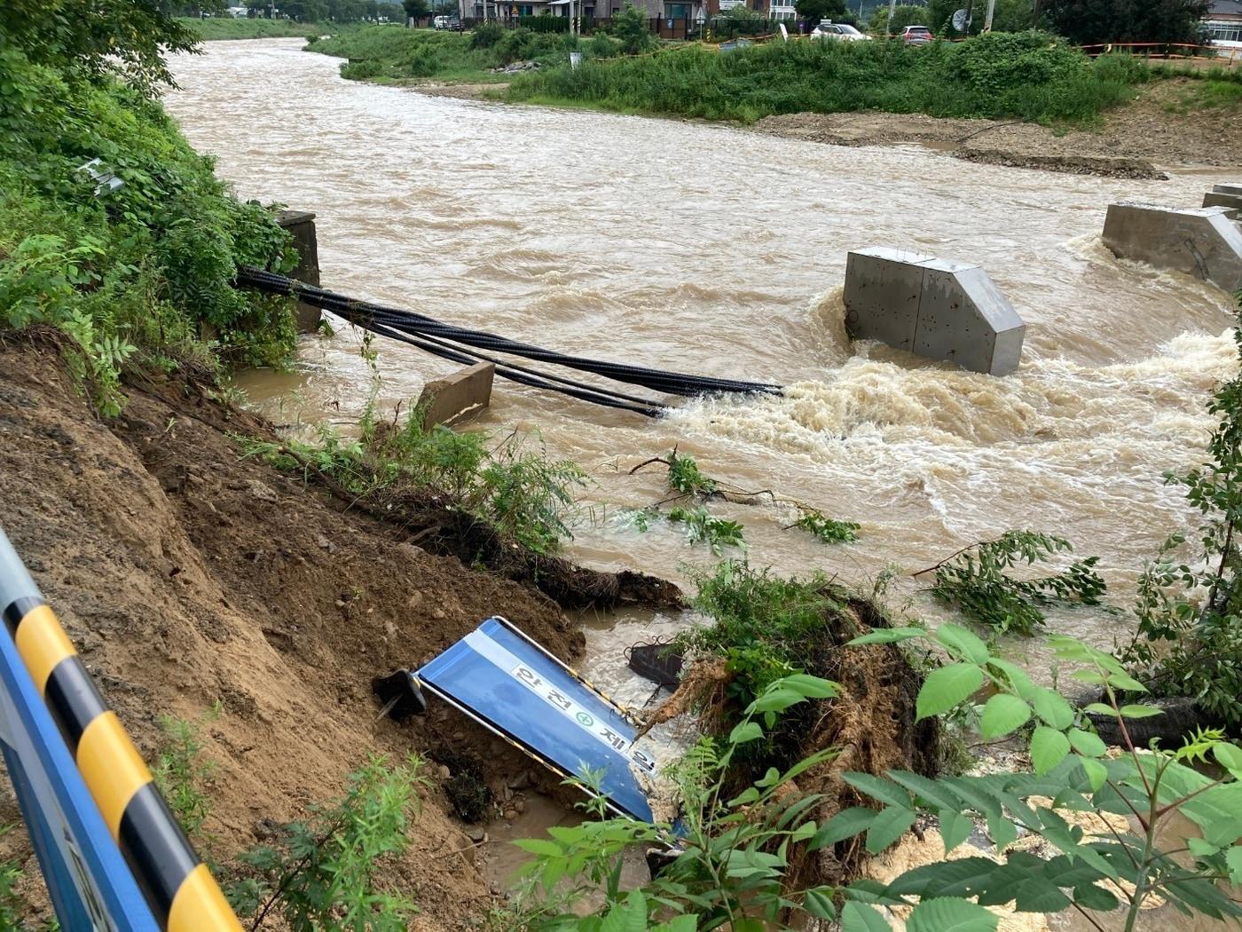 본문 이미지 - 15일 천안 목천읍 산방천의 물이 불어나면서 동리교 인근 하천 제방이 유실됐다. (천안시청 제공)