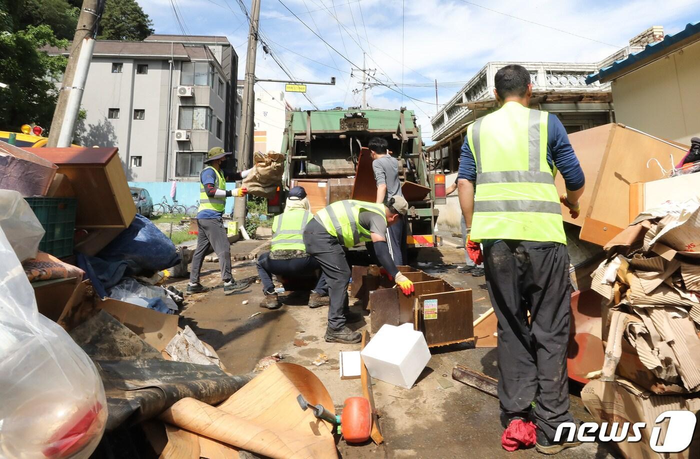 충남 공주시 옥룡동 일대 폭우 침수현장에서 주민들과 자원봉사자들이 물에 젖은 가구 등을 옮기고 있다./뉴스1 ⓒ News1 임세영 기자