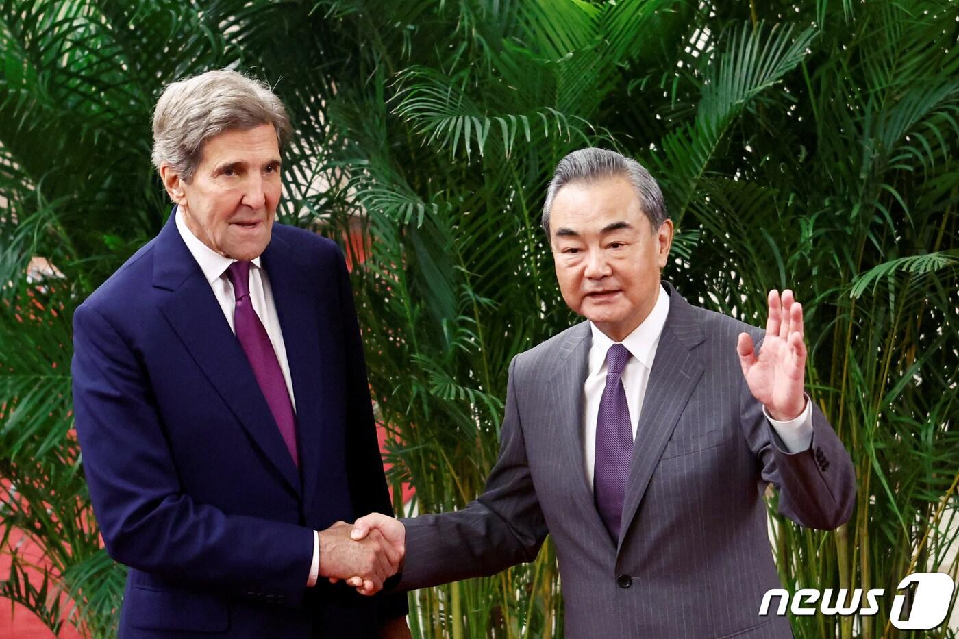 18일(현지시간) 베이징 인민대회당에서 열리는 회담에 앞서 존 케리 미국 기후특사(왼쪽)와 왕이 중국 공산당 중앙정치국 위원 겸 중앙 외사판공실 주임이 만나 악수를 나누고 있다. 2023.07.18 ⓒ 로이터=뉴스1 ⓒ News1 정지윤 기자