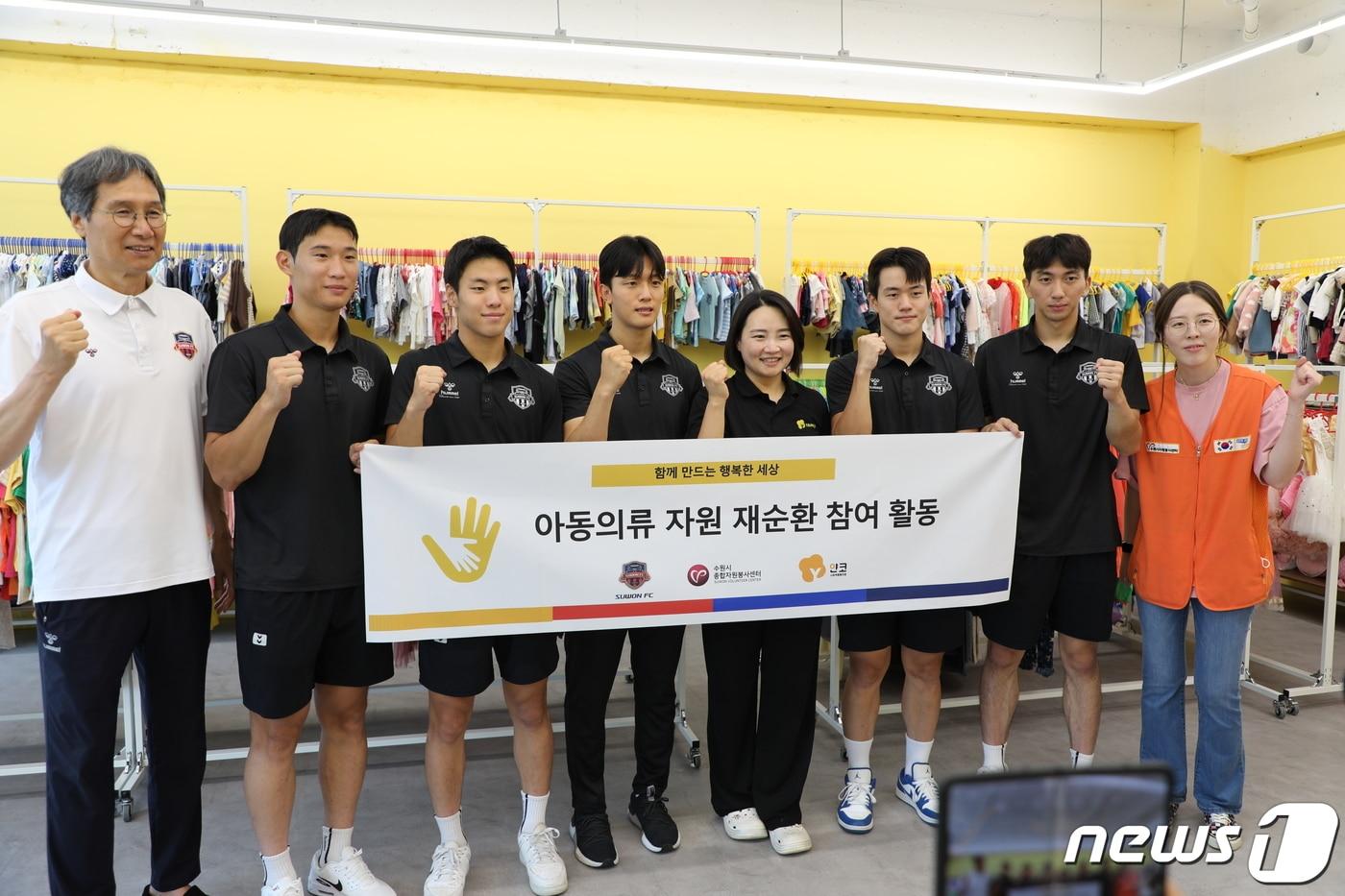 본문 이미지 - 수원FC 최순호(맨 왼쪽) 단장과 선수들이 18일 수납공간 정리 등 봉사활동을 마친 뒤 정나겸 얀코 사회적협동조합(오른쪽에서 네 번째) 이사장과 기념촬영을 하고 있다.(수원시 제공)