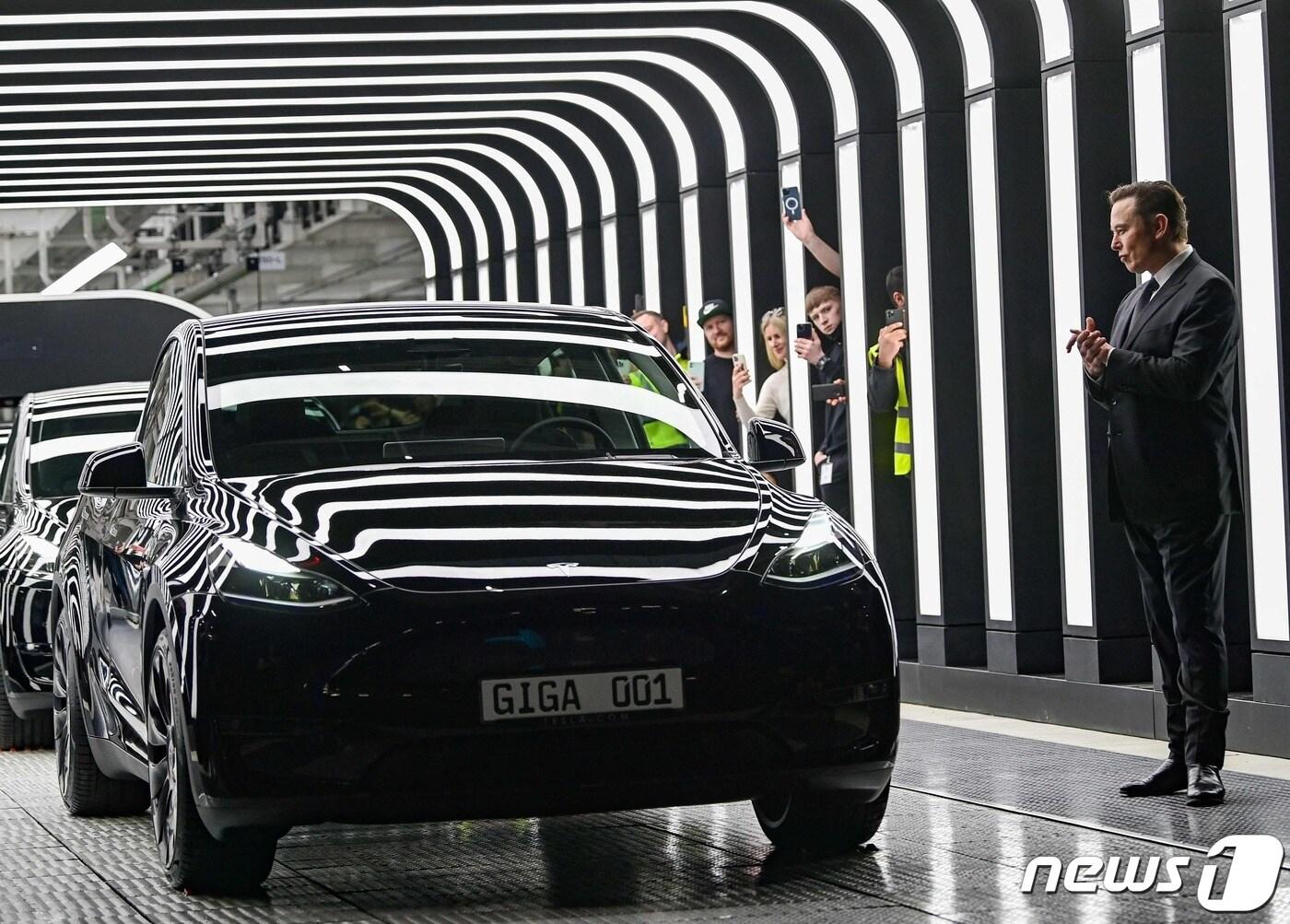 본문 이미지 - 테슬라의 일론 머스크 최고경영자가 베를린 그륀하이데 기가팩토리에서 생산된 차량을 보고 있다. 2022.3.22ⓒ AFP=뉴스1