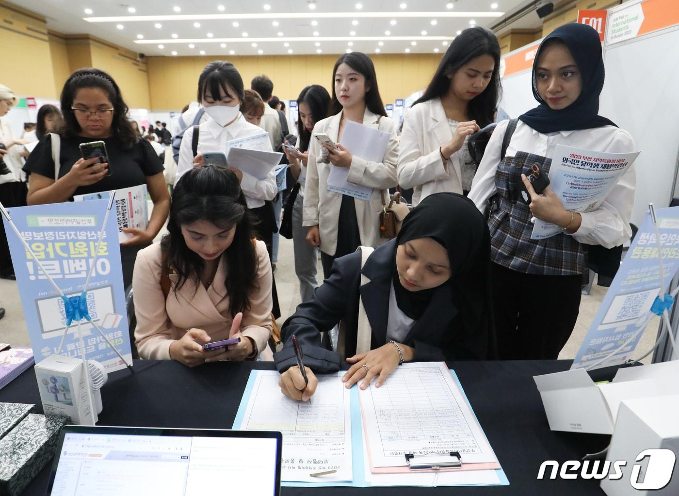 본문 이미지 - 20일 오후 부산 동구 부산항국제전시컨벤션센터에서 열린 '2023 부산 지역특화형 비자 외국인 유학생 채용박람회'에서 외국인 유학생들이 부산일자리정보망 회원가입을 하고 있다. . 2023.7.20/뉴스1 ⓒ News1 윤일지 기자
