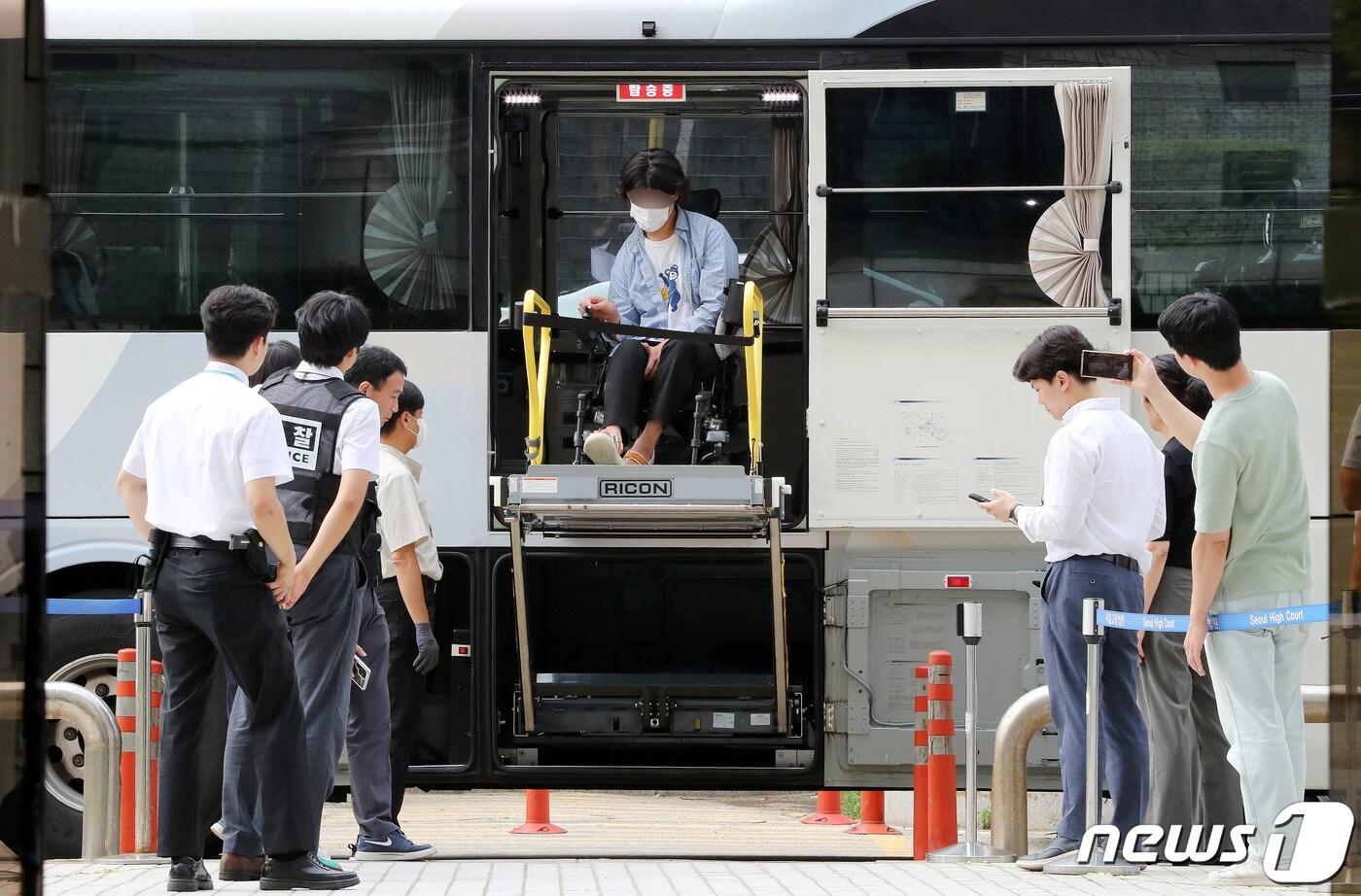 본문 이미지 - 버스 시위 중 경찰 팔을 깨문 전장연 활동가 유모씨가 20일 오후 서울 서초구 서울중앙지방법원에서 열린 공무집행방해 혐의 구속영장 실질심사에 출석하기위해 서울장애인버스에서 하차하고 있다. 2023.7.20/뉴스1 ⓒ News1 박세연 기자