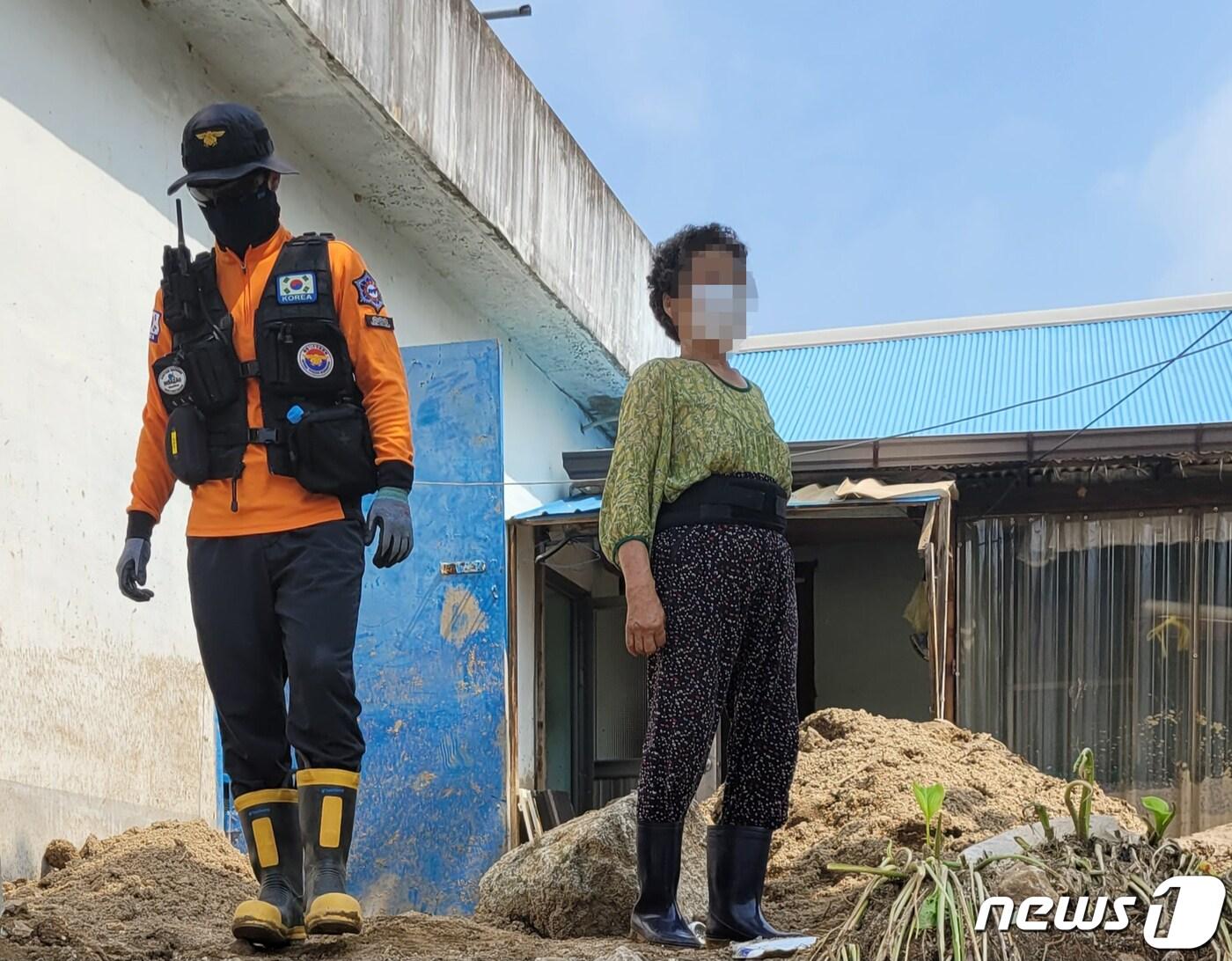 본문 이미지 - 20일 경북북부지역의 집중호우로 피해를 입은경북 예천군 감천면 벌방리에서 주민 4명 코로나 확진자로 판정돼 감천면 마을 주민과 응급 복구 인력이 마스크를 착용하고 있다.2023.7.20/뉴스1 ⓒ News1 정우용 기자