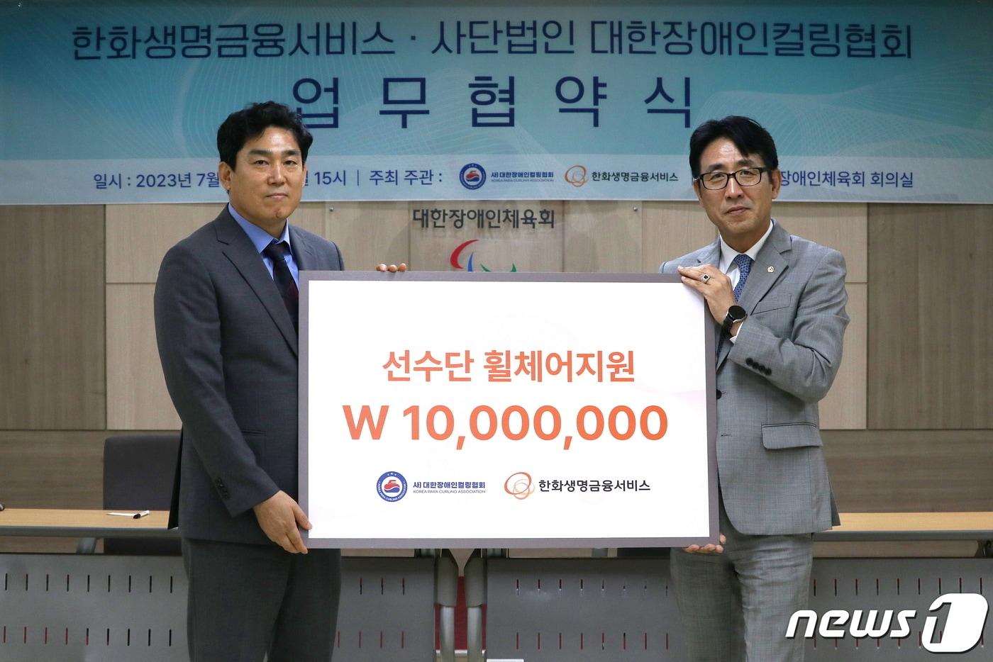 본문 이미지 - 한화생명금융서비스가 20일(목) 대한장애인 체육회에서 대한장애인컬링협회 측에 1천만원 상당의 선수용 휠체어 2대를 전달했다. 한화생명금융서비스 박종선 금융소비자보호실장(사진 오른쪽)과 대한장애인컬링협회 서영원 실무 부회장(사진 왼쪽)이 기념 촬영을 하고 있다.