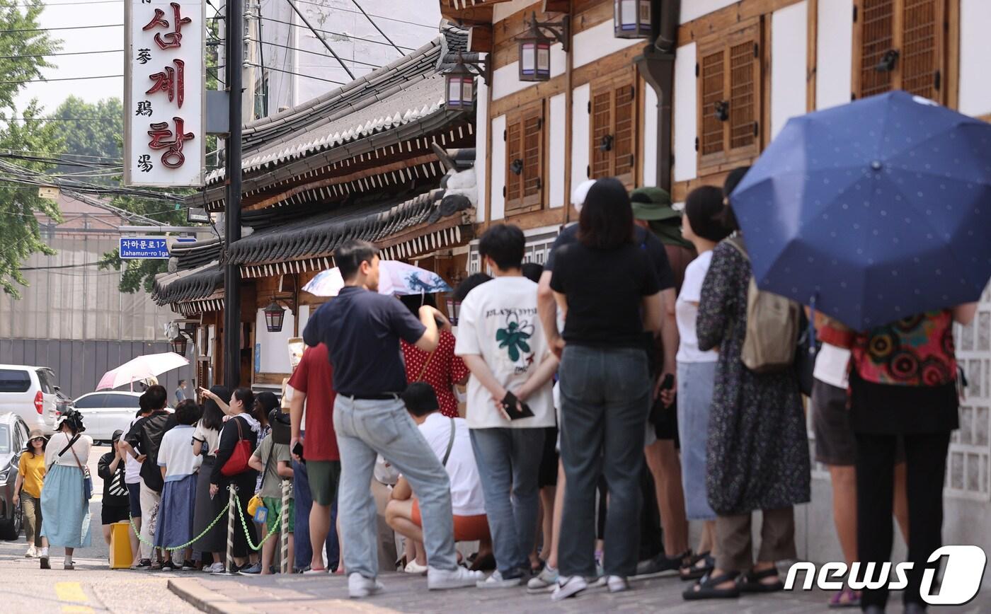 본문 이미지 - 삼복(三伏) 중 중복인 21일 오후 서울 시내의 한 삼계탕 전문점에서 시민과 관광객들이 점심식사를 하기 위해 줄을 서고 있다. 2023.7.21/뉴스1 ⓒ News1 구윤성 기자