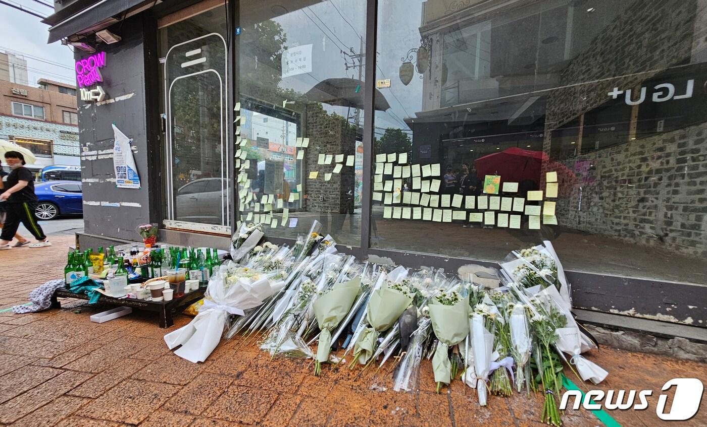 본문 이미지 - 지난달 22일 서울 관악구 신림역 인근 '묻지마 흉기난동' 사건이 일어난 현장에 사망한 20대 A씨를 추모하는 국화꽃이 놓여 있는 모습. (독자 제공)  ⓒ News1 