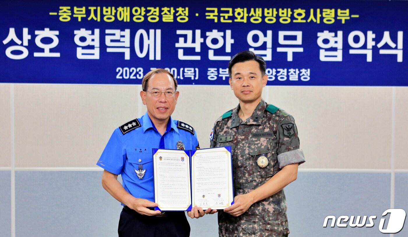 본문 이미지 - 김병로 중부지방해양경찰청장(왼쪽)과 유재훈 국군화생방방호사령관이 화생방 테러 및 사고 대응 상호 협력에 관한 업무 협약을 체결한 후 기념사진을 촬영하고 있다.(중부지방해양경찰청 제공) / 뉴스1