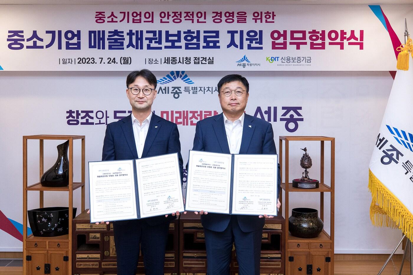 본문 이미지 - 심현구 신용보증기금 전무이사(사진 왼쪽)과 이승원 세종시 경제부시장이 지난 24일 세종시청에서 열린 '매출채권보험 보험료 지원 업무협약'을 체결한 후 기념 촬영을 하고 있다. (신보 제공)