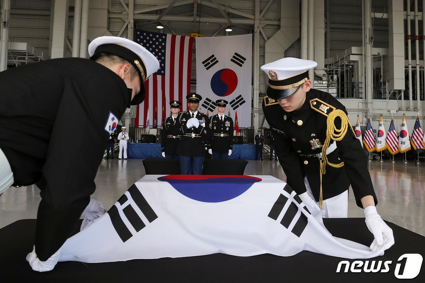 본문 이미지 - 25일(현지시간) 미국 하와이 히캄 공군기지에서 열린 국군전사자 유해 인수식에서 국군의장대가 유엔사로부터 인계받은 소관을 태극기로 관포하고 있다. 미국 하와이에 있던 6·25전쟁 당시 국군 전사자 유해 7위는 73년 만에 고국으로 돌아오게 됐다. (국방일보 제공) 2023.7.26/뉴스1