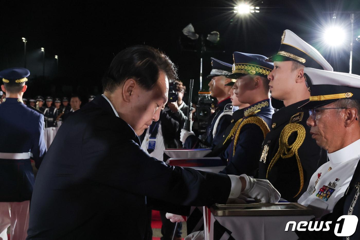 본문 이미지 - 윤석열 대통령이 지난 26일 경기 성남 서울공항에서 열린 국군 전사자 유해 봉환 행사에서 6·25전쟁 당시 전사해 하와이에 임시 안치됐던 7명의 국군 용사 유해에 참전기장을 수여하고 있다. (대통령실 제공) 2023.7.26/뉴스1 ⓒ News1 오대일 기자