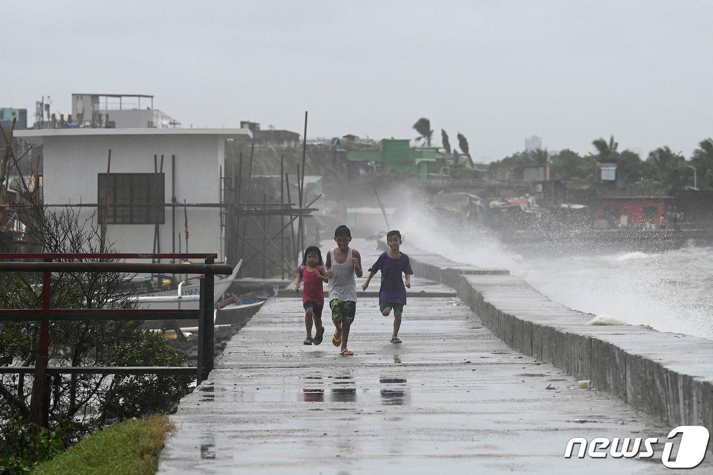 26일(현지시각) 필리핀 마닐라 외곽지역인 나보타스에서 아이들이 방파제를 따라 뛰고 있다.2023.07.26/ ⓒ AFP=뉴스1 ⓒ News1 윤주영 기자