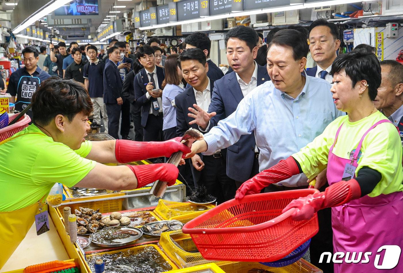 윤석열 대통령이 27일 부산 중구 자갈치시장을 찾아 수산물 시장 상황을 점검하며 장어를 들어보이고 있다. 2023.7.27/뉴스1 ⓒ News1 부산사진공동취재단