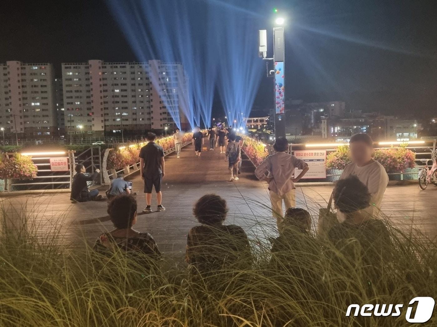 본문 이미지 - 강원 강릉지역에 5일 연속 열대야 현상이 나타난 27일 강릉시 월화교를 찾은 시민들이 야간 조명을 감상하며 무더위를 식히고 있다. 2023.7.27/뉴스1 ⓒ News1 윤왕근 기자