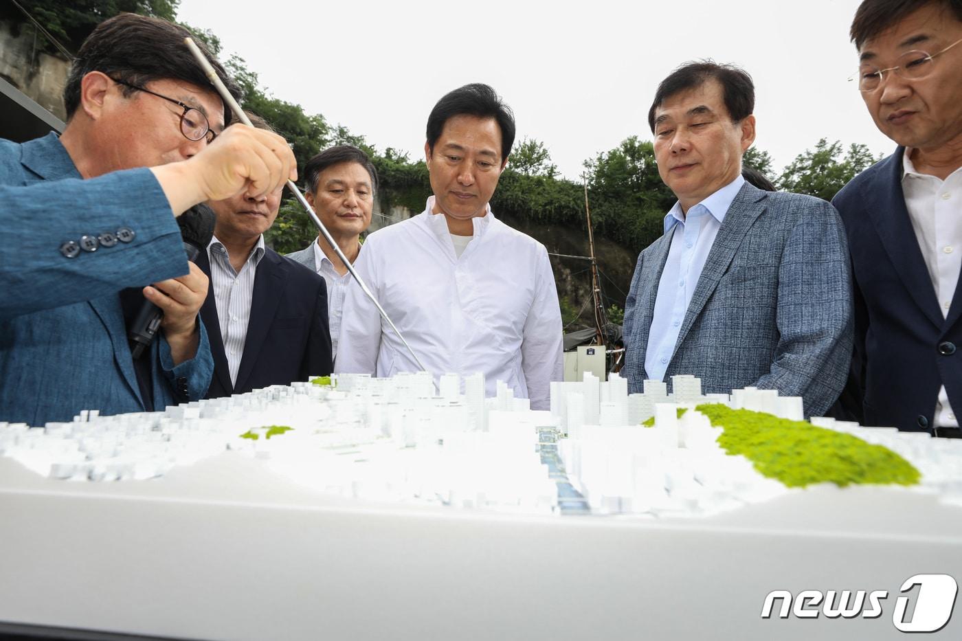 본문 이미지 - 오세훈 서울시장이 지난해 7월 서울 종로구 창신동 신속통합기획안 재개발 후보지를 찾아 관계자의 현장 보고를 듣고 있다. 2023.7.5/뉴스1 ⓒ News1 김민지 기자