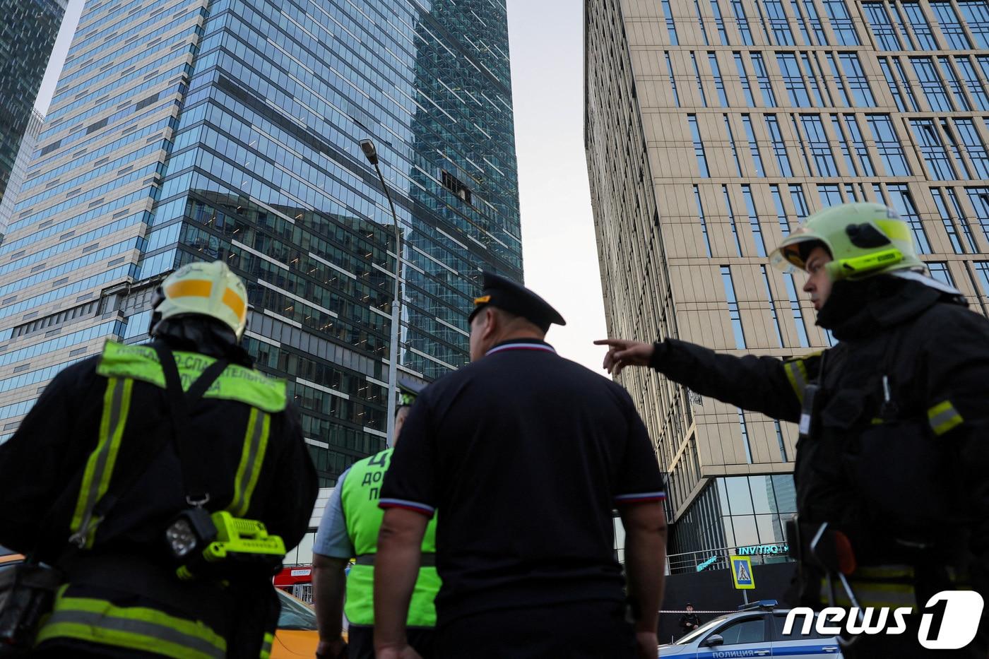 본문 이미지 - 러시아 수도 모스크바 상업지구의 고층 건물이 우크라이나의 무인기 공격을 받아 안전 요원들이 상황을 살피고 있다. 2023.08.01/ ⓒ 로이터=뉴스1