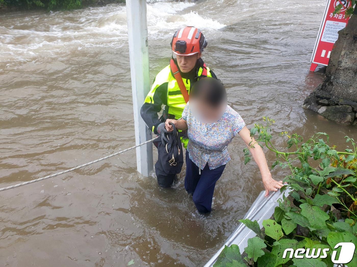 본문 이미지 - 제6호 태풍 카눈이 북상한 10일 오전 경남 창원시 마산회원구에서 소방대원이 불어난 물로 고립된 주민을 구조하고 있다. (소방청 제공) 2023.8.10/뉴스1